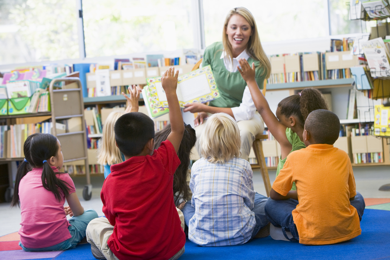 Blond teacher teaching young girls and boys